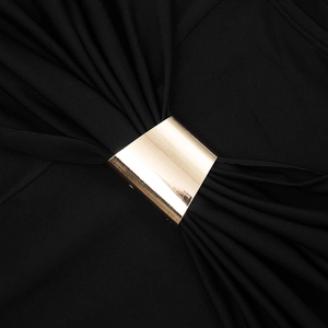 Detail eines schwarzen Strickoberteils mit polierter goldener Metallschnalle und Falten