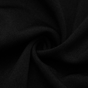 Close-up of black knitted fabric texture with pleated details and mesh weave structure