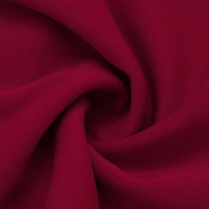 Gros plan du tissu tricoté rouge foncé avec une texture douce et extensible