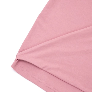 Detailed close-up of pink knit dress hem featuring clean side slit and refined stitching