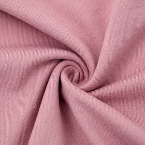 Detail of soft dusty rose knit fabric with elegant pleated texture and draped design