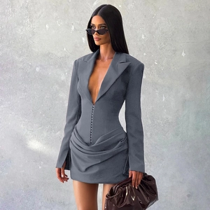 Detailed close-up of corset-style waist tailoring and pleated skirt on a grey blazer dress