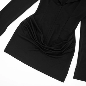 Detail view of black V-neck mini dress showing cross pleated waist and drapery fabric