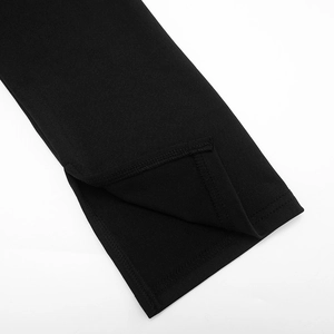 Detail view of the black knitted dress sleeve with a side slit and refined stitching