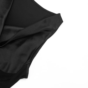 Detail of black satin fabric featuring sheer mesh patchwork and a glossy silk-like finish