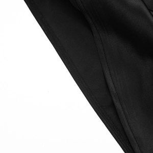 Detail shot of the precise stitching and glossy mesh fabric on the black sleeveless dress