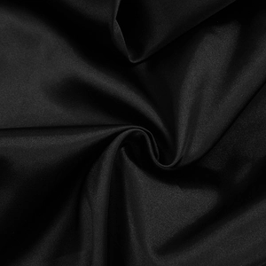 Macro shot of high-density black satin fabric with elegant silk luster and drapes