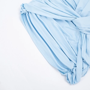 Vue détaillée du nœud torsadé et du tissu plissé sur la robe moulante bleu clair