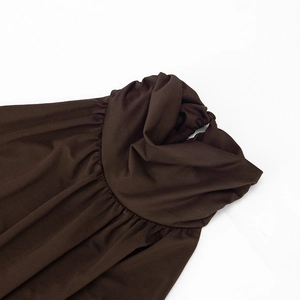 Detailansicht des eleganten Neckholder-Ausschnitts mit weicher Faltenstruktur in Braun