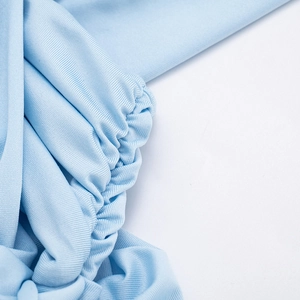 Gros plan détaillé du tissu côtelé bleu clair avec texture plissée et reflet soyeux