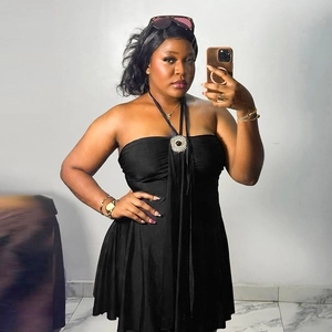 Close-up of black halter neck dress featuring a large crystal-studded circular metallic ornament