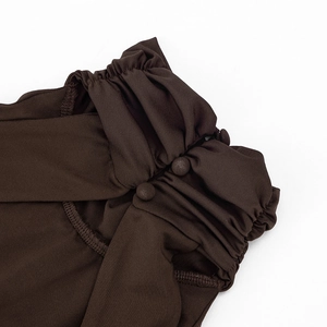 Detail von dunkelbraunem gerafftem Ausschnitt mit drei stoffbezogenen Knöpfen am Kleid
