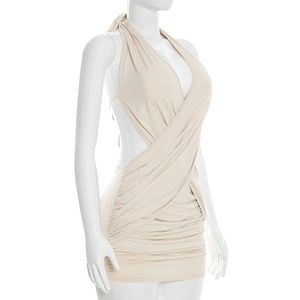 Détail d'une mini-robe licou beige avec découpe latérale et tissu plissé croisé