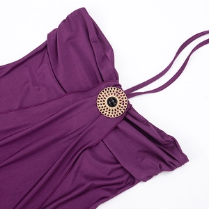 Detail of purple ruched dress featuring a gold circular buckle with black gemstone inlay