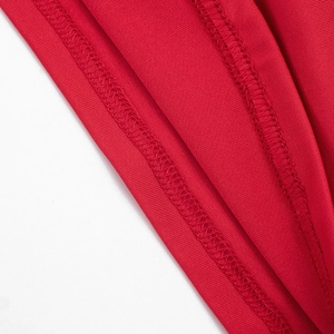 Vue macro de la texture en maille rouge et des finitions d'ourlet précises sur la robe
