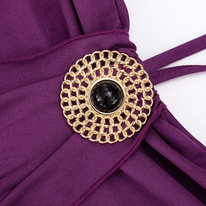 Detail of purple ribbed fabric with a golden woven buckle and black jewel centerpiece