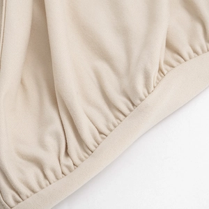Vue macro de la texture en maille côtelée abricot et détail de l'ourlet pour robe mini