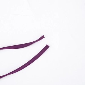 Detailed view of dark purple halter neck ties with fine textured fabric on an elegant dress