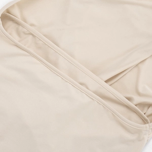 Gros plan détaillé du tissu en maille beige clair avec coutures et bretelles croisées
