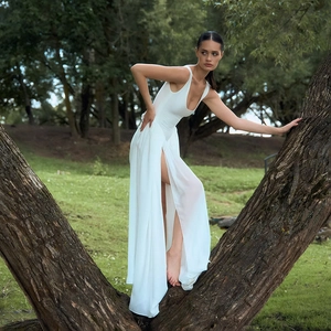 Detailed view of the elegant high side slit on a white sleeveless chiffon summer dress
