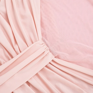 Detailed view of pink satin pleats and mesh fabric stitching on halter mini dress