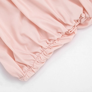 Detail of pink knitted dress featuring high-elastic pleated waist and neat stitching