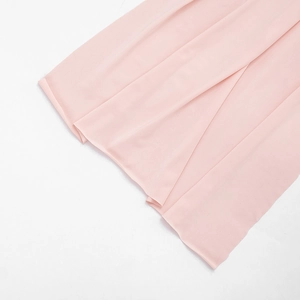 Detailed macro view of light pink chiffon dress fabric with elegant drapery and soft folds