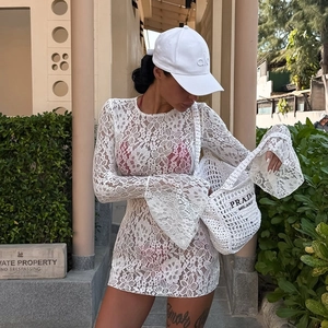 Detail of white floral lace cover-up dress with pink bikini set and woven beach tote
