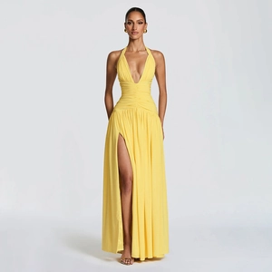Detailed view of yellow halter maxi dress with deep V-neck, pleats and high leg slit
