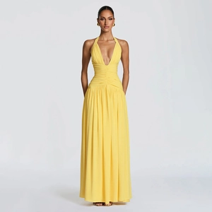 Detail view of the elegant deep V-neck and pleated waist on a yellow halter maxi dress