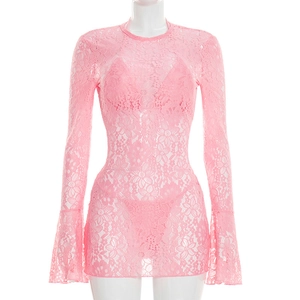 Detailed macro view of pink floral lace fabric on a long sleeve beach cover-up dress