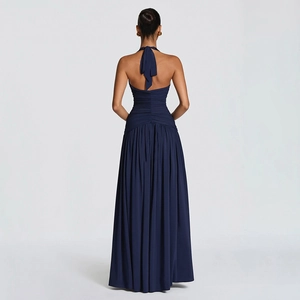 Detail of navy blue halter dress featuring an open back and pleated maxi skirt silhouette