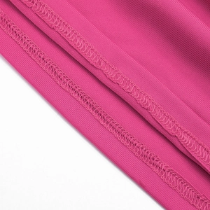 Gros plan sur le tissu côtelé rose rouge montrant les coutures et la texture élastique