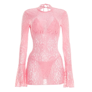 Detailed texture of pink sheer floral lace fabric with flared sleeves on a beach cover-up
