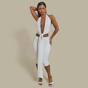 Detail of white halter neck top with stylish knot decoration and high waist skirt