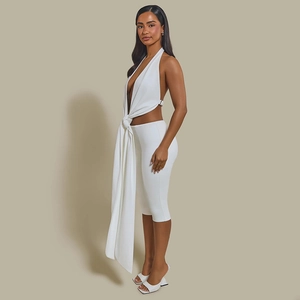 Detail of white halter neck crop top with tassel detail and matching capri leggings set