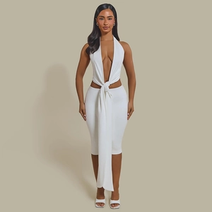 Detail view of white halter dress featuring a deep V-neck and twist knot waist design
