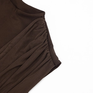 Detail of dark brown dress featuring ruched mesh fabric and knitted patchwork design