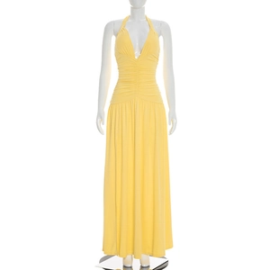 Close-up of the elegant light yellow halter neck maxi dress with a deep V-neckline and pleats
