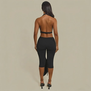 Close-up of black backless halter top with thin back straps and high-waist tight trousers