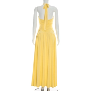 Detail view of the elegant yellow halter backless maxi dress with ruched waist and draping