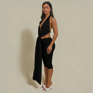 Detail of black halter neck top with decorative waist tie and matching slim fit shorts