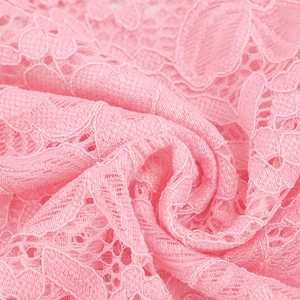 Close-up of vibrant pink lace fabric featuring intricate floral hollow-out patterns