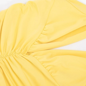 Detail view of the yellow ruched fabric and textured stitching on this elegant summer dress