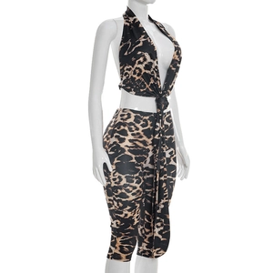 Detail of sexy leopard print two-piece set with halter neck top and slim fit skirt