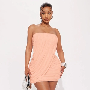 Detail of elegant peach strapless mini dress featuring ruched mesh fabric and slim fit design