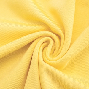 Close-up of bright yellow ribbed knit fabric showing soft texture and fine fiber details