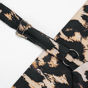 Detail of adjustable shoulder strap with silver metal buckle on leopard print dress