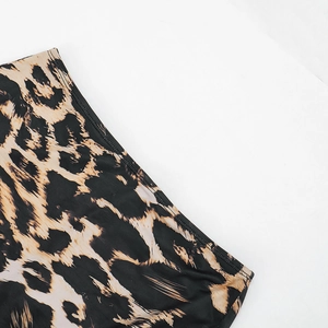 Close-up of leopard print fabric detail with fine black stitching on the hem edge