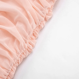 Close-up of light pink sheer mesh fabric detailing with elastic ruched texture
